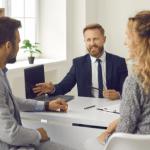 Young professional couple in office with loan officer.