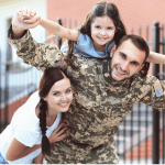 Military Dad with his daughter and his wife smiling.